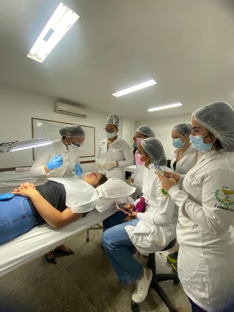 Aula prática em laboratório com turma de Farmácia acompanhando procedimento